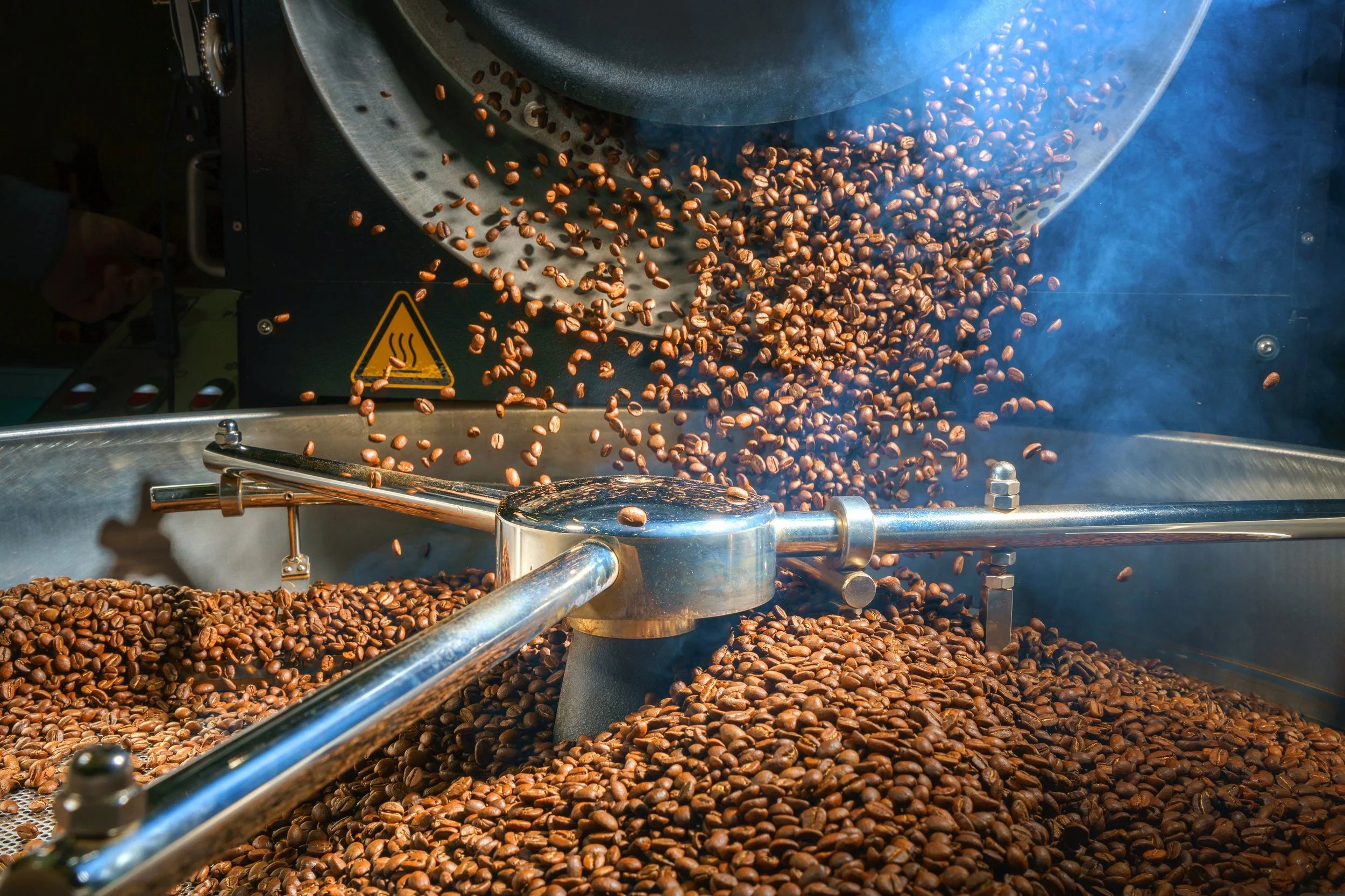 Roasting drum dropping fresh-roasted beans into the cooling tray